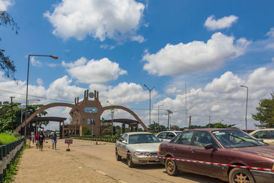 Cars on street by buildings against sky