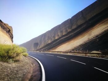 Road by mountain against clear sky