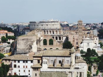 Coliseum and buildings against clear sky