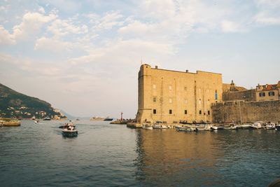 Boats in sea against buildings