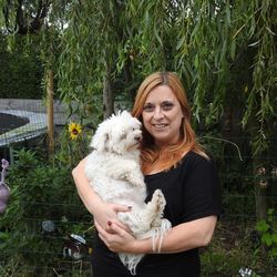 Portrait of smiling mid adult woman holding dog in park