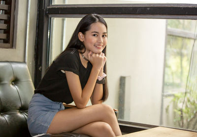 Portrait of smiling girl sitting at home