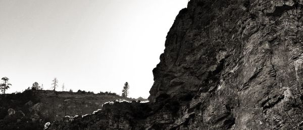 Low angle view of rocky mountains against clear sky