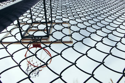 Low angle view of chainlink fence against sky