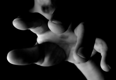 Close-up of hands against black background