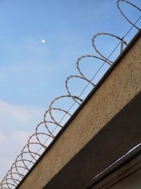 Low angle view of fence against sky