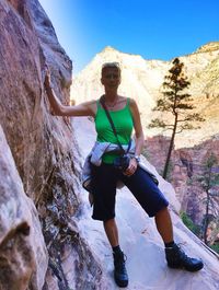 Full length portrait of woman standing by rock formation at zion national park