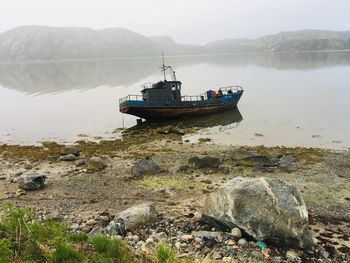 Fishing boat on rocks by sea