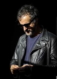 Midsection of man wearing sunglasses against black background