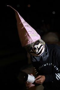 Midsection of man wearing mask in dark