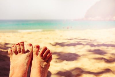Low section of person relaxing on beach