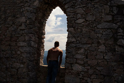 Rear view of man standing by wall