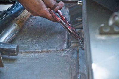 Midsection of man working on metal