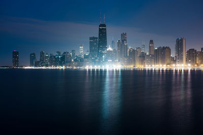 Illuminated buildings in city against sky at night