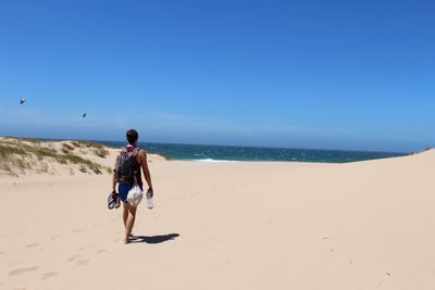 Full length of man on beach against clear sky