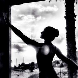 Rear view of silhouette woman standing against sky