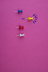 High angle view of multi colored toy on pink background