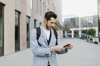 Young man using mobile phone in city