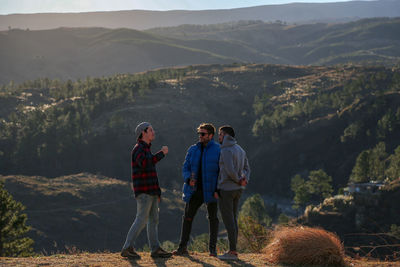 Rear view of man standing on mountain, friends having a good weekend