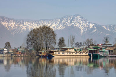 Scenic view of lake by snowcapped mountains against sky