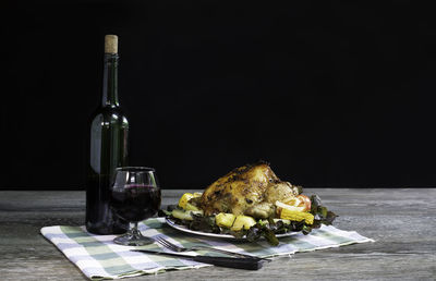 Close-up of wine bottles on table against black background