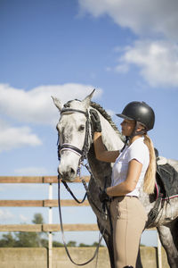 Woman riding horse cart against sky