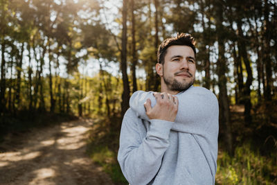 Portrait of young man standing in forest
