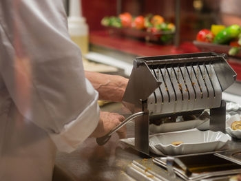 Midsection of chef preparing food in restaurant