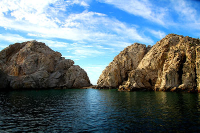 Rock formations by sea against sky