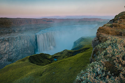 Scenic view of waterfall against sky