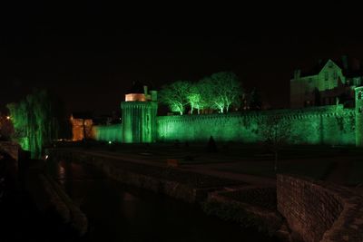 Illuminated buildings against sky at night