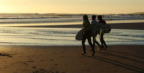 View of surfers walking on the beach