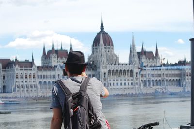 Rear view of man standing against building