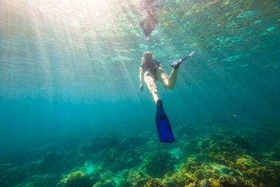 Low angle view of young woman swimming in sea