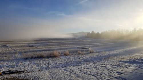 Scenic view of snow covered land against sky