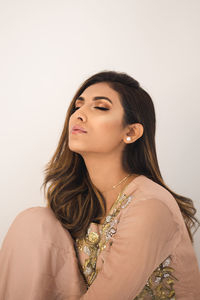 Young woman looking away against white background