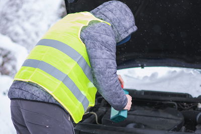 Rear view of man repairing car