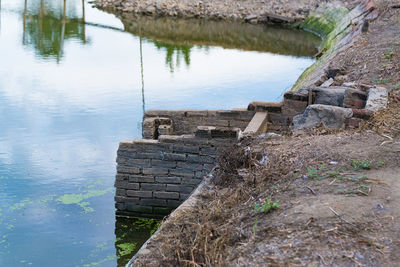 High angle view of old stone wall by lake