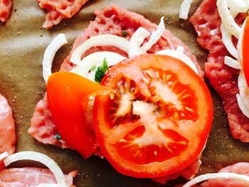 High angle view of onions and tomatoes on meat