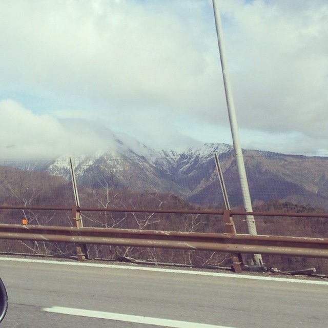 mountain, transportation, sky, mountain range, cloud - sky, road, cloudy, cloud, railing, connection, scenics, mode of transport, nature, tranquil scene, tranquility, day, bridge - man made structure, beauty in nature, weather, the way forward