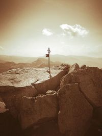 Man standing on rock against sky