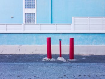 Multicolored wall and red posts against building