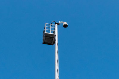 Low angle view of electric lamp against blue sky