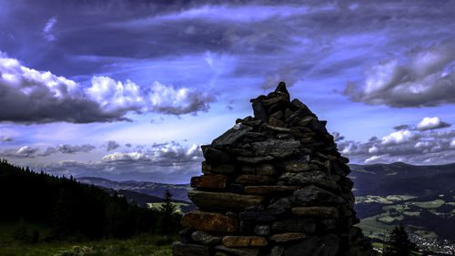 Stack of rocks on mountain against sky