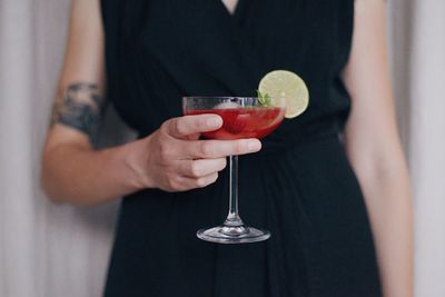 Midsection of woman drinking glass