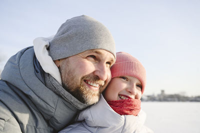Happy father and daughter wearing knit hats in winter