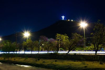 Illuminated street light against clear sky at night