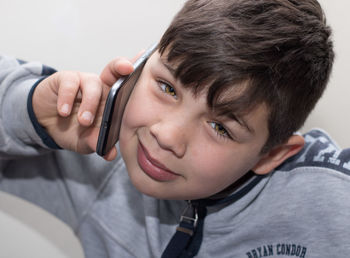 Portrait of boy talking on mobile phone at home