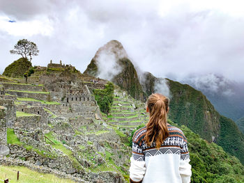 Rear view of woman standing against mountain