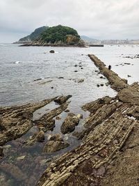 Scenic view of rocks on beach against sky